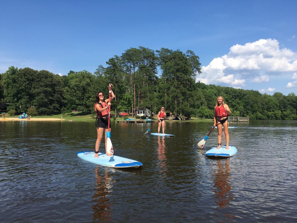 Pratiquante de stand up paddle sur un plan d'eau calme et abrité